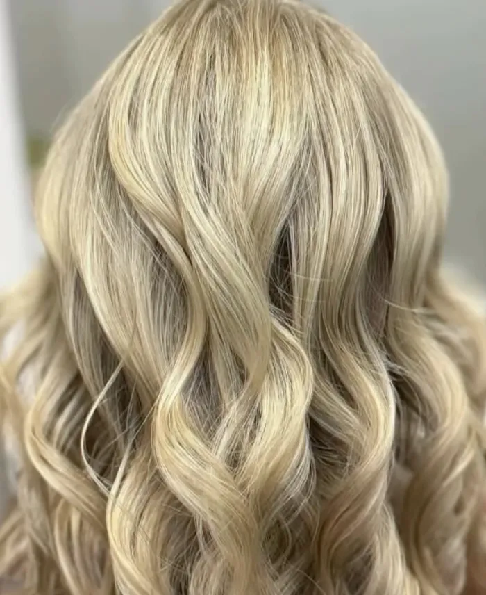 Wavy, shoulder-length blonde hair viewed from the back. Copperfalls Aveda Spa & Salon, Castle Rock, CO